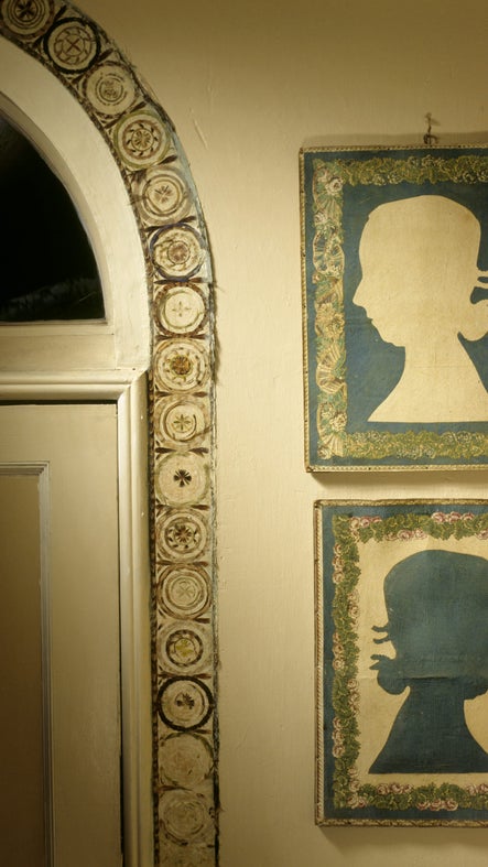 Positive and negative reliefs of Mary Walrond beside the feather frieze around the door in the Drawing Room at A la Ronde, Devon.